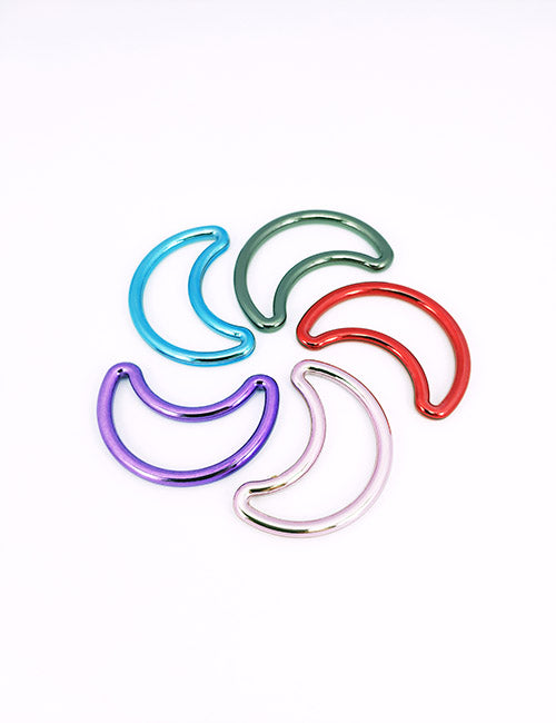 Five crescent-shaped Adornments by YIPAI in blue, green, red, purple, and silver are arranged in a circular pattern on a white background.