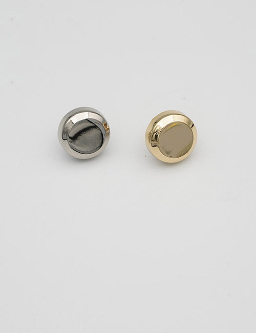 Two round, flat Adornments by YIPAI are displayed on a plain white background; one features a silver finish, the other a gold finish.