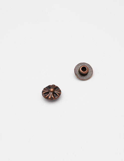 Two small, round, bronze-colored Adornments beads by YIPAI are shown on a white background. One features a fluted, flower-like design; the other reveals its flat back with a central hole.