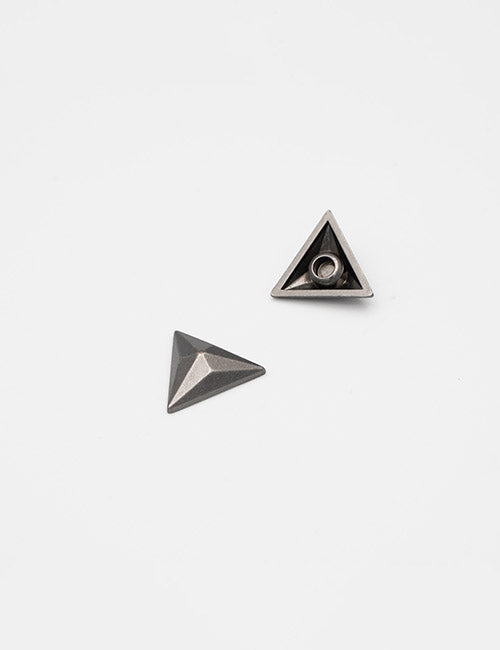 Two small, metallic YIPAI Adornments with triangular bases are displayed on a white background; one is upright and the other flipped to show its hollow underside.