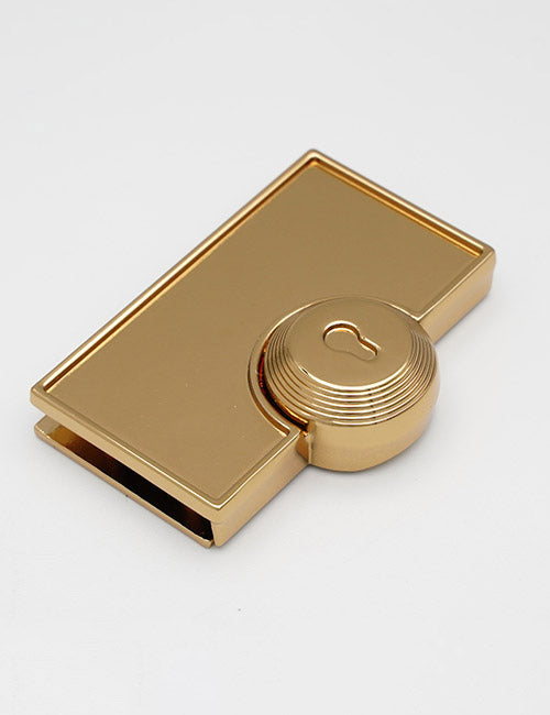 The YIPAI Closures is a rectangular gold money clip with a round, ridged center engraved with a keyhole symbol, displayed on a plain white background.