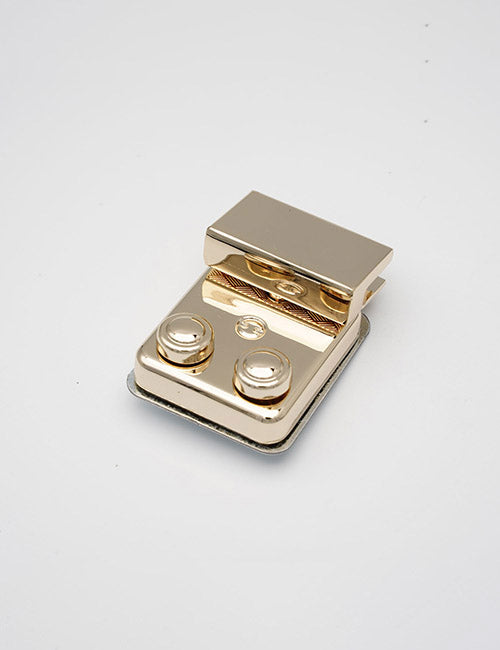 A YIPAI Closures metal clasp, gold-colored with two round fasteners and a rectangular hinge, displayed on a plain white background.