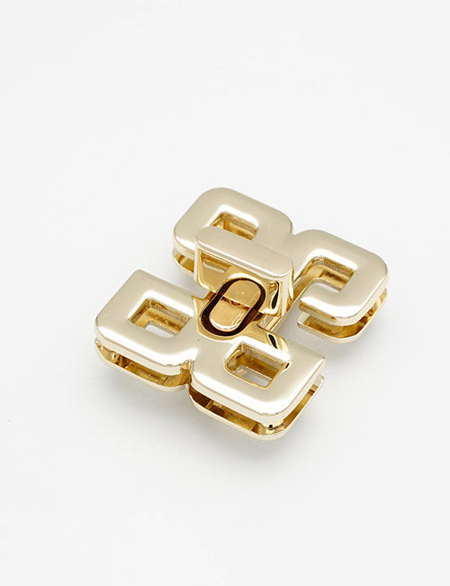 A YIPAI Closures gold metal clasp with a geometric design—two interlocking rectangles and a central oval mechanism—displayed on a white background.