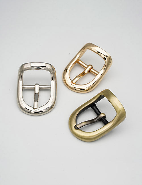 YIPAI Buckles: Three metal buckles in silver, gold, and bronze are displayed on a plain light gray surface. Each features a simple, rounded rectangular design with a center prong.
