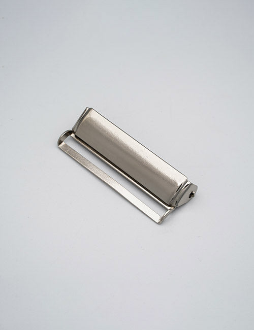 A YIPAI Buckles silver metal tube squeezer with a rotating handle rests on a light gray background, designed to squeeze out contents from tubes like toothpaste or paint.