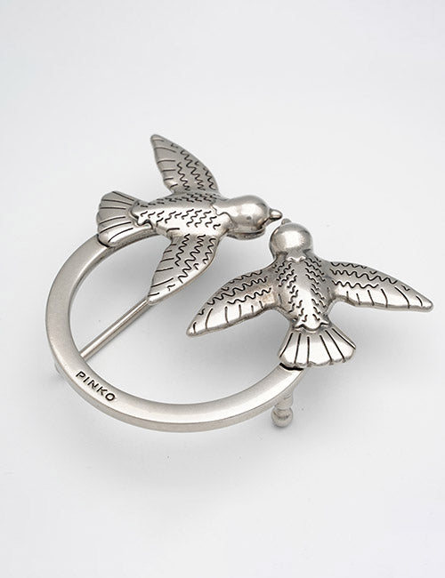 A silver buckle by YIPAI features two stylized birds facing each other, touching beaks, with engraved wing details. The YIPAI brand name appears on the circular part of the buckle.