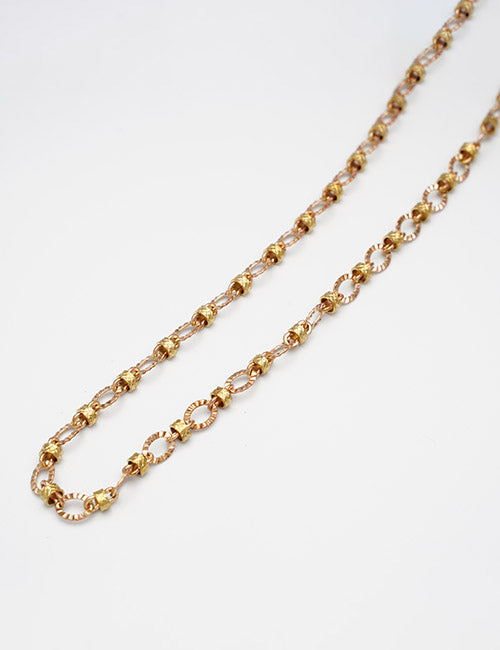The YIPAI Chains necklace features small, intricate round links with textured and smooth segments, made of delicate gold, shown against a plain white background.