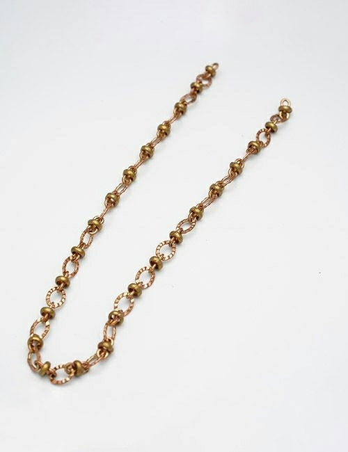 The YIPAI Chains necklace features alternating small round and oval gold links, elegantly arranged in a gentle curve on a plain white background.
