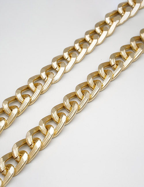 Two YIPAI Chains necklaces with thick, flat gold-colored links are displayed parallel to each other on a plain white background.