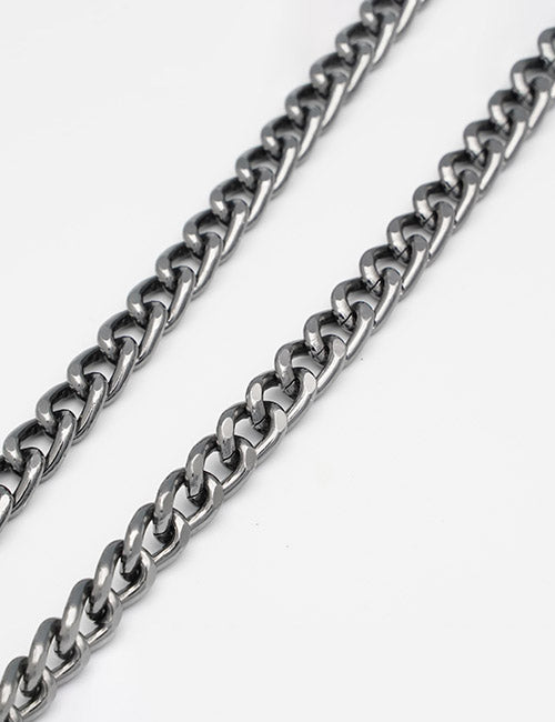 Two YIPAI Chains silver curb necklaces are arranged diagonally on a plain white background, highlighting their interlocking links and polished finish.