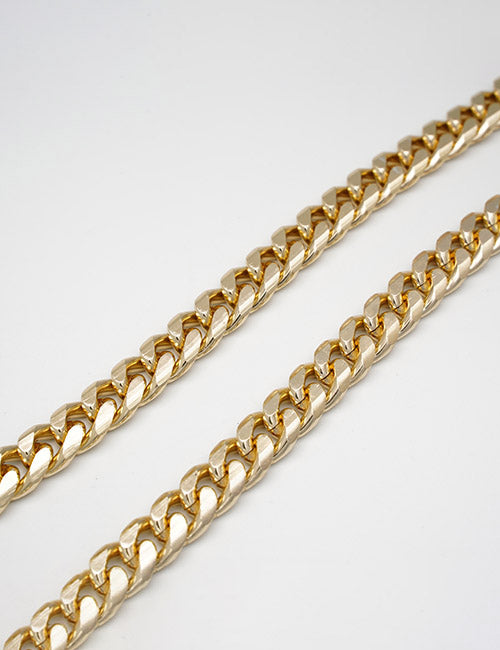 Two YIPAI gold Cuban link chains are laid parallel on a plain white background.