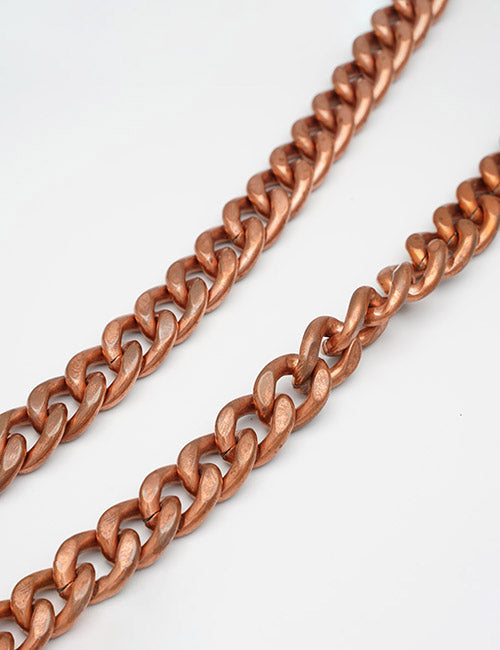 Two copper-colored YIPAI Chains with thick oval links are laid parallel to each other on a white background.