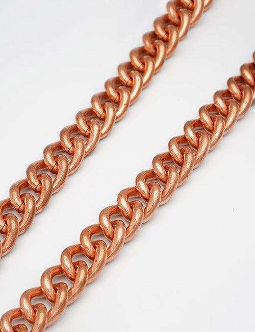 Close-up of two YIPAI Chains in rose gold color, placed parallel on a white background.