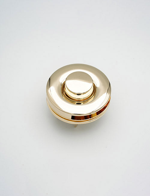 A shiny, round, gold-colored YIPAI Closures product with a central raised button, shown from above against a plain white background.
