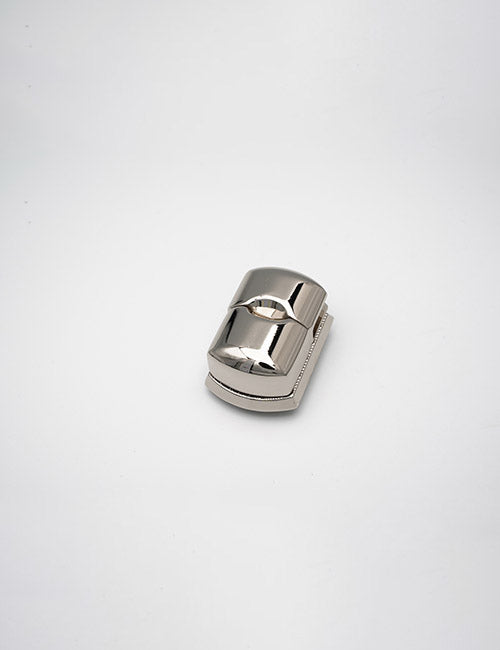 A YIPAI Closures pencil sharpener with a shiny metallic finish and single blade is displayed on a plain white background.
