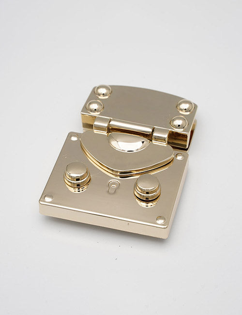 The YIPAI Closures features a shiny gold metal clasp with rounded edges, decorative screws, two round knobs, and a keyhole, displayed on a plain white background.