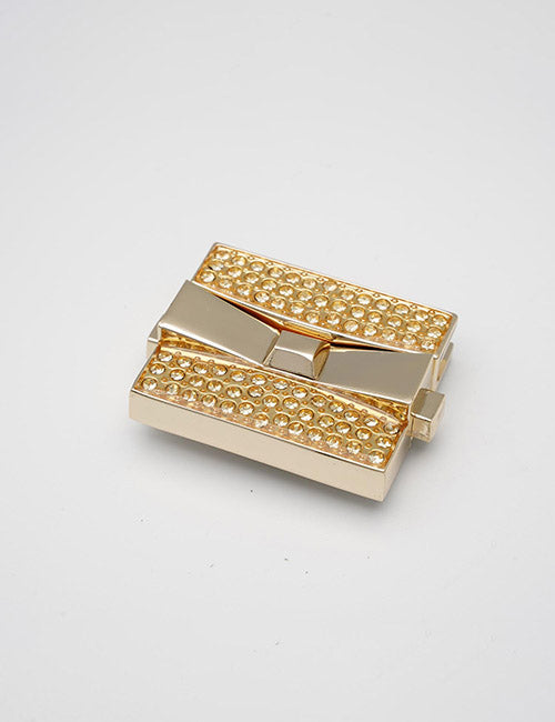 The YIPAI Closures is a rectangular, gold-colored clasp with a shiny finish and small, round, gem-like embellishments, displayed against a plain white background.