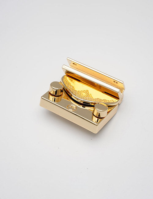 The YIPAI Closures is a gold and silver metal cigar cutter featuring a textured, curved blade and two round knobs, shown on a plain white background.