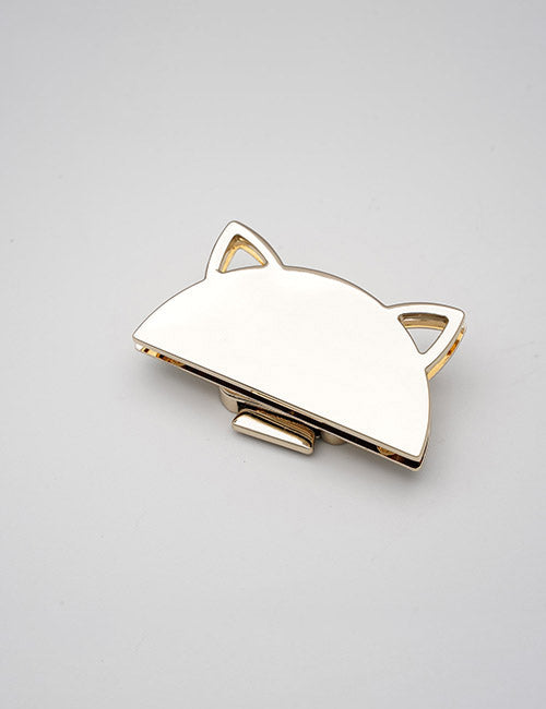YIPAIs Closures: a gold-colored metal hair clip shaped like a cat’s head with two pointed ears, shown on a plain light gray surface.