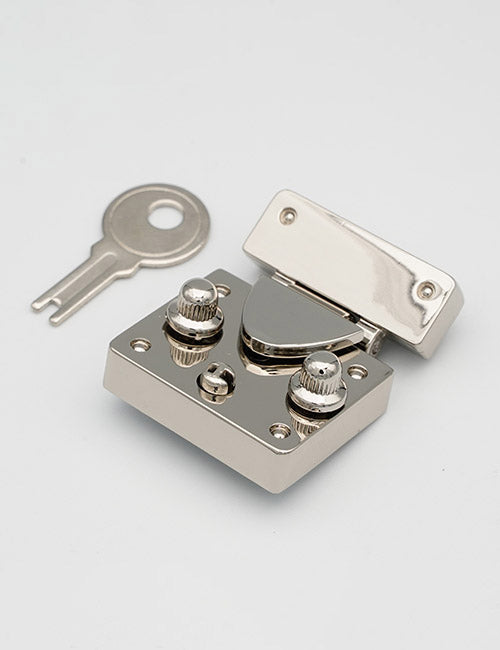 A YIPAI Closures silver metal box lock with two dials and a hinged lid is displayed beside its matching flat key on a plain white background.