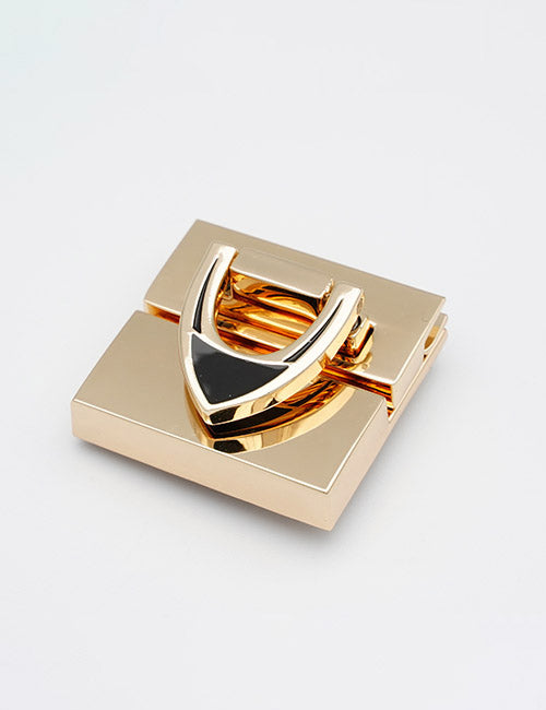 A gold, square-shaped metal closure by YIPAI with a shiny finish and U-shaped design on top, displayed on a plain white background.