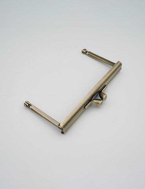 A YIPAI Closures brass-colored metal purse frame with clasp closure and two side hinge arms, shown on a plain light gray background.