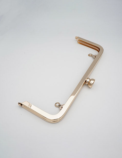 A shiny, gold-colored YIPAI Closures metal purse frame with a curved rectangular shape, two attachment loops, and a central clasp is displayed against a plain white background.