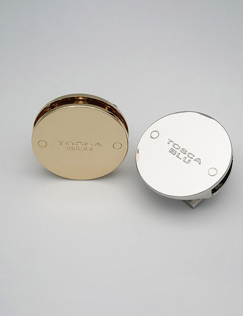 Two round metallic YIPAI Closures, one in gold and one in silver, are displayed on a plain light grey surface.