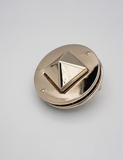 A YIPAI Closures round, shiny gold clasp with a raised pyramid-shaped center is shown against a plain light gray background.