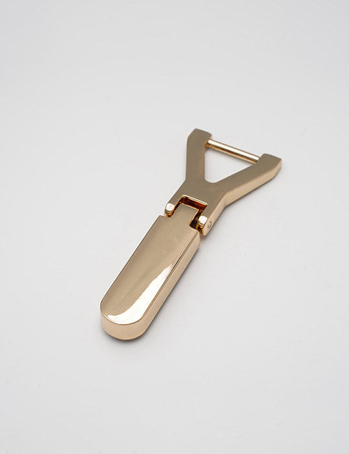 A sleek, metallic gold YIPAI Fasteners product with a modern, minimalist design lies on a plain white background. The handle features an open, Y-shaped structure.
