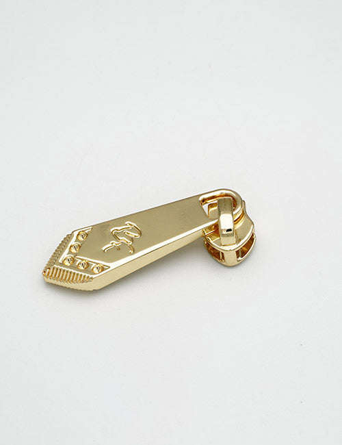 A YIPAI Fasteners shiny gold zipper pull tab with an engraved design, displayed on a plain white background.