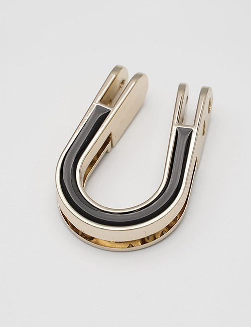 A YIPAI Handles U-shaped money clip in metallic gold with a black enamel inlay, shown on a plain white background.