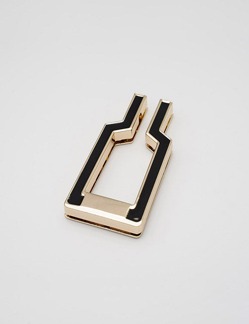 The YIPAI Handles is a gold metal belt buckle with a geometric, bottle-inspired shape and black enamel inlay, shown on a plain light gray background.