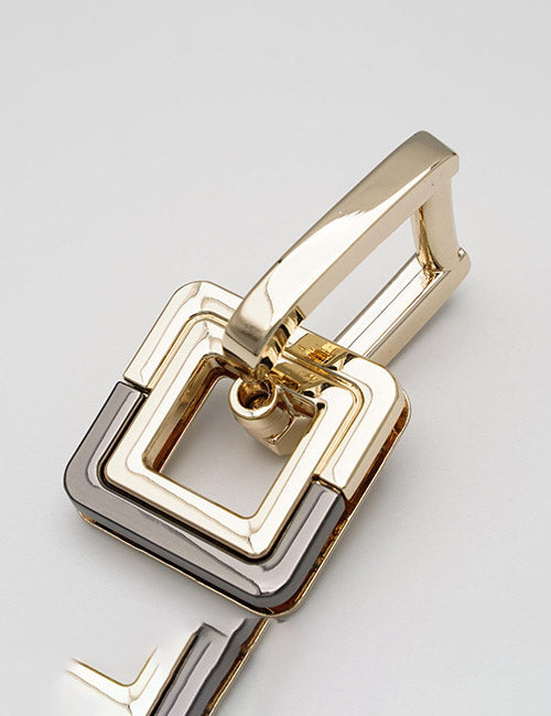 A close-up of YIPAI Handles, featuring interlocking square and rectangular shapes in gold and black metal, displayed on a light grey background.
