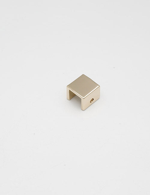 A small, square-shaped gold metal handle by YIPAI with an open bottom and a hole on one side is placed on a plain white background.