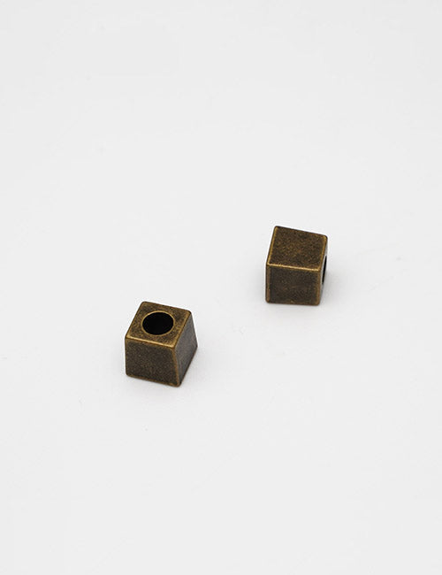 Two small, matte bronze metal YIPAI Handles, each cube-shaped, with one featuring a circular hole on top, displayed on a plain white background.