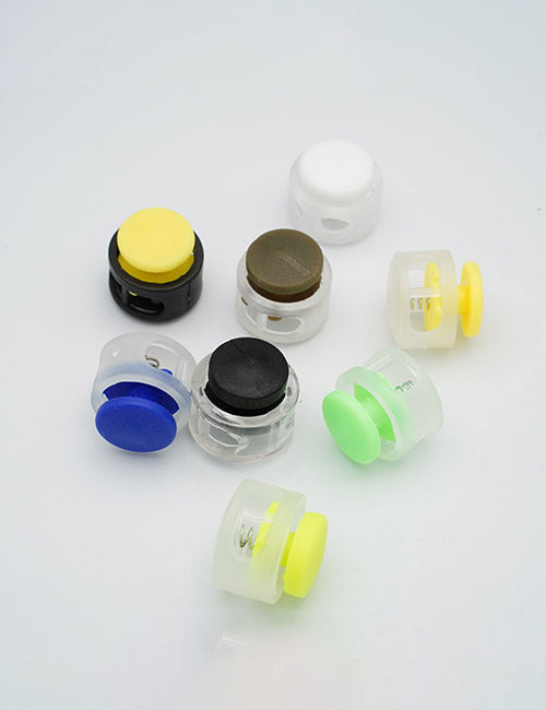Eight small, round YIPAI Handles in yellow, blue, green, black, white, and brown are arranged on a plain white surface.