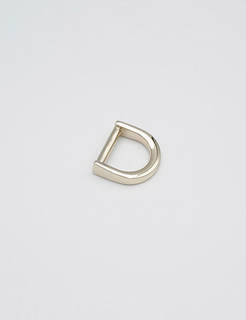 A YIPAI Rings & Slides gold metal D-ring buckle is displayed on a plain, light gray background.