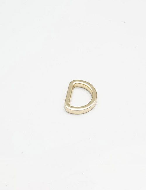 A single YIPAI Rings & Slides gold D-ring rests on a plain white background.