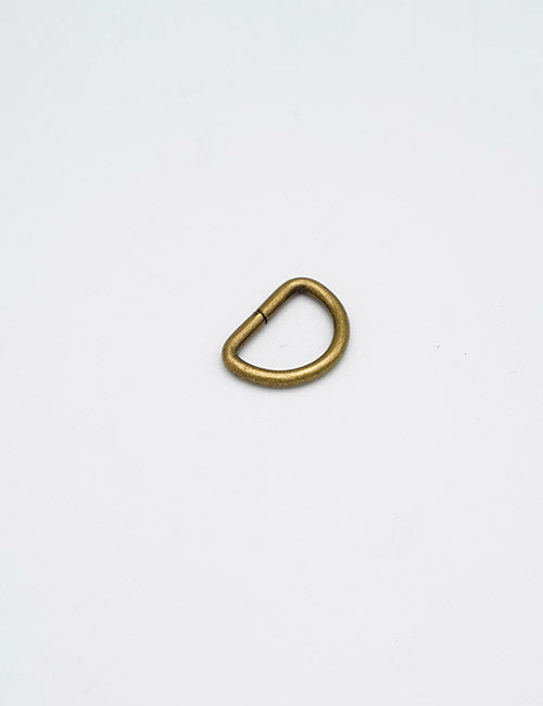A YIPAI Rings & Slides brass D-ring rests on a plain white background.