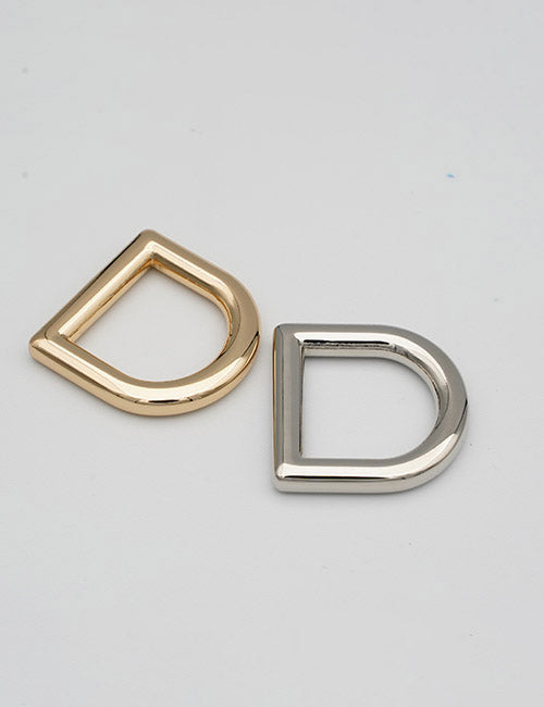 Two metallic D-rings from YIPAI Rings & Slides, one gold and one silver, are displayed side by side on a plain light gray background.