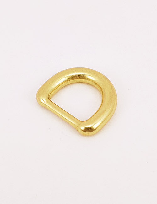 A gold-colored metal D-ring from YIPAIs Rings & Slides collection rests on a plain white background.