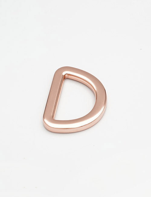 A smooth, shiny rose gold D-ring from YIPAIs Rings & Slides collection lies flat on a plain white background, featuring rounded edges and a metallic finish.