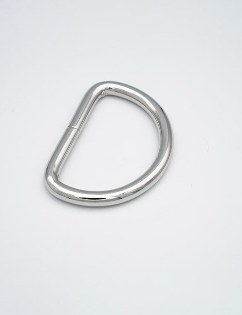A YIPAI Rings & Slides silver metal D-ring rests flat on a plain white surface, with its straight edge to the left and the curved semicircular edge facing right.