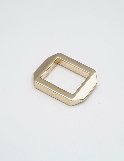 A gold-colored, geometric, rectangular metal buckle with beveled edges from YIPAIs Rings & Slides collection is displayed on a plain light gray background.