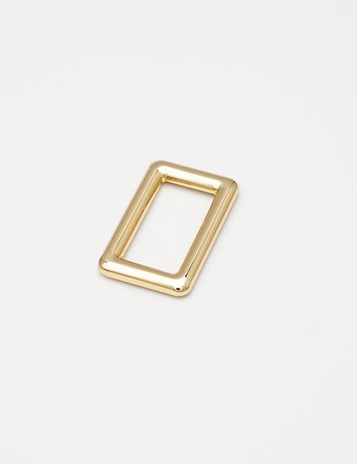 A shiny, rectangular gold metal Rings & Slides buckle by YIPAI, featuring rounded edges, is displayed on a plain white background.