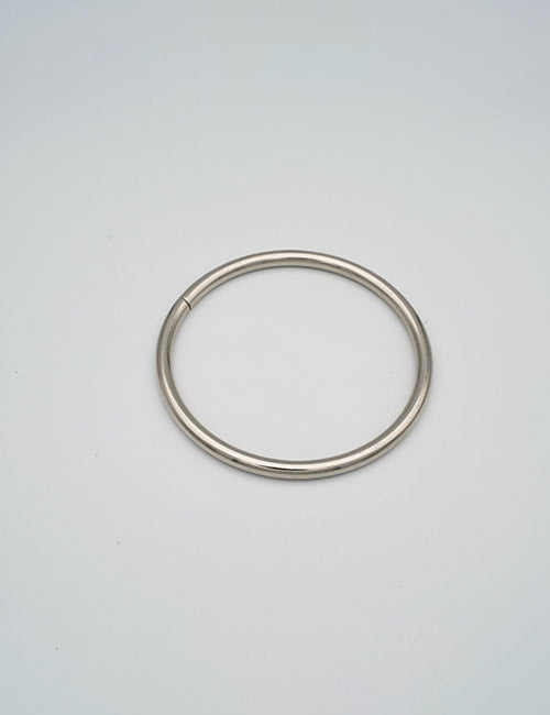 A single YIPAI Rings &Slides metal key ring lies flat on a light grey background.