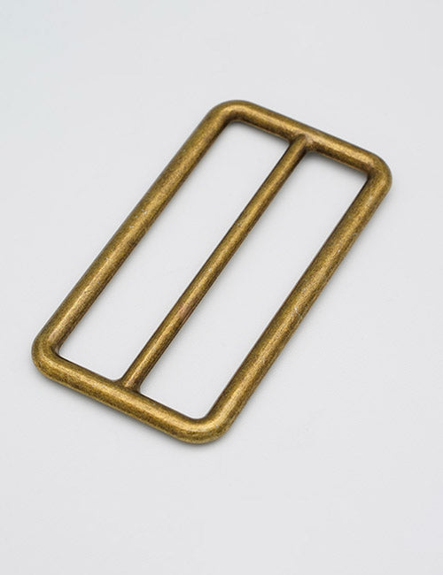 The YIPAI Rings & Slides is a rectangular, brass-colored metal buckle with rounded edges and a central bar, shown on a plain white background.