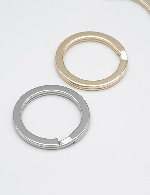 Two simple Rings & Slides by YIPAI, one gold and one silver, are placed overlapping on a plain white surface.