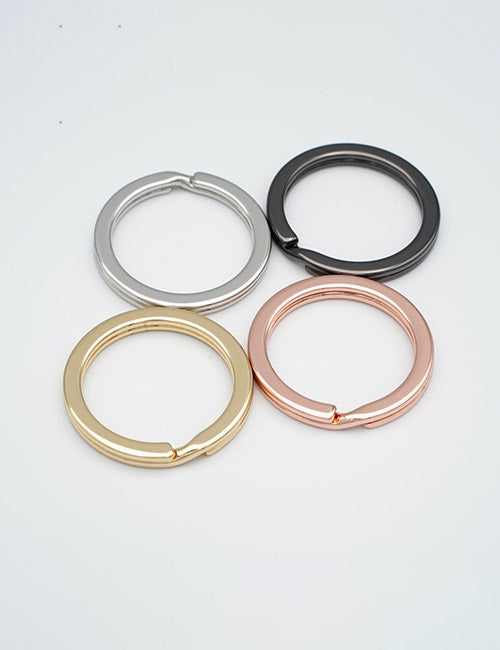 Four YIPAI Rings & Slides metal key rings in silver, black, gold, and rose gold are arranged in a square pattern on a white background.